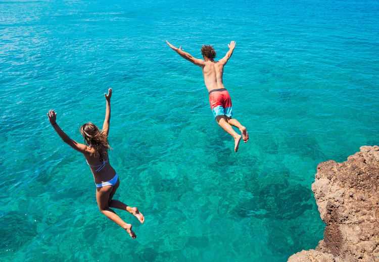 Summer fun, Friends cliff jumping into the ocean.